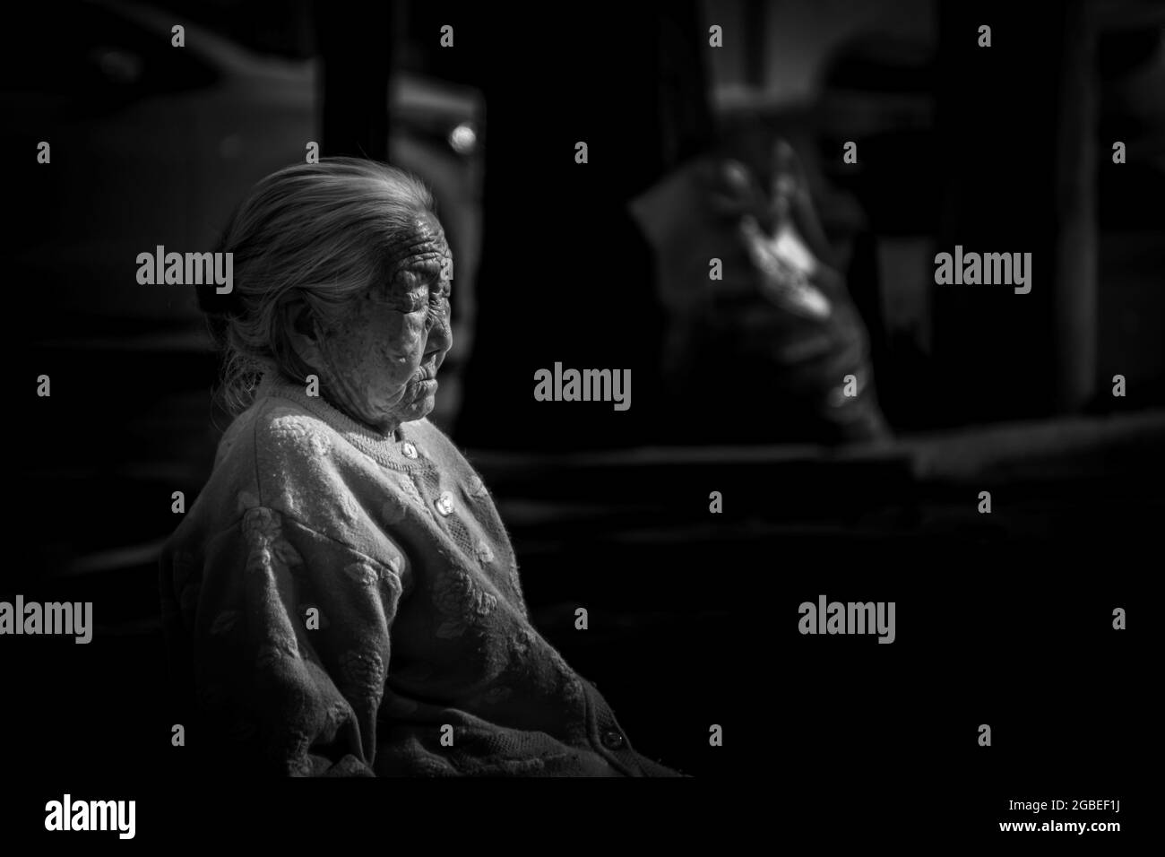MOKPO, KOREA, SOUTH - Apr 09, 2015: A grayscale shot of an elderly blind Korean lady sitting on a bench in Mokpo City, South Korea. Stock Photo