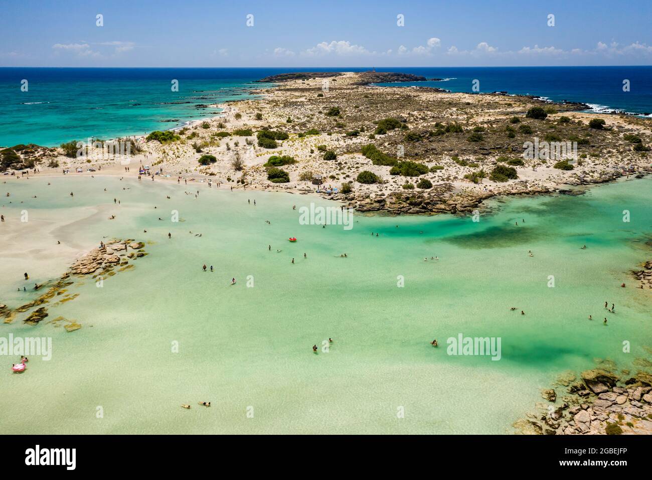 Aerial view of shallow sandy lagoons and a beach surrounded by deeper dark blue sea (Elafonissi Beach) Stock Photo