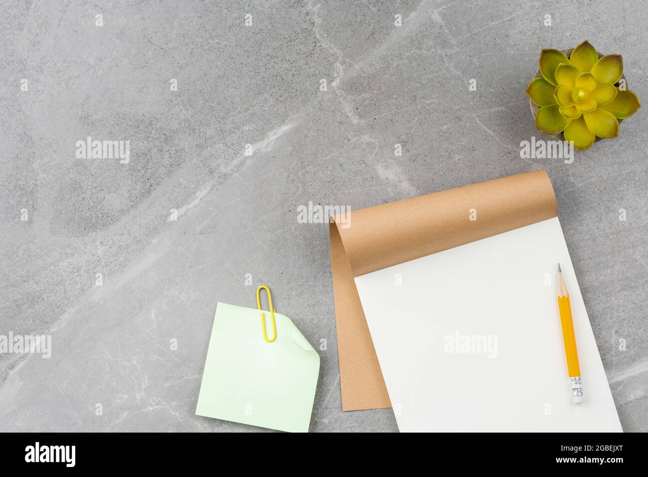 Open notepad on gray marble background. Stock Photo