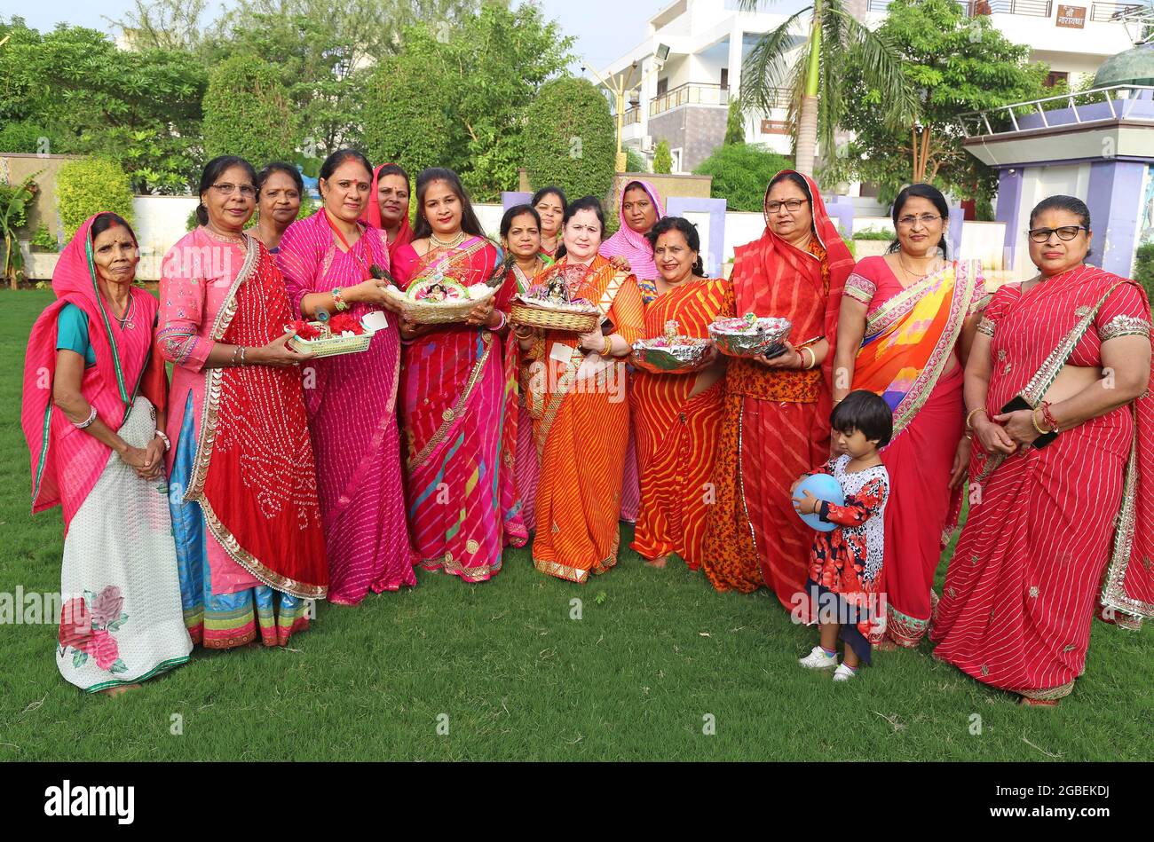 Beawar, India. 02nd Aug, 2021. Hindu women wearing colorful lahariya saree, pose for a picture with the idols of Laddu Gopal (Lord Krishna) as they celebrate the holy month of Sawan (Shravan) in Beawar. (Photo by Sumit Saraswat/Pacific Press) Credit: Pacific Press Media Production Corp./Alamy Live News Stock Photo