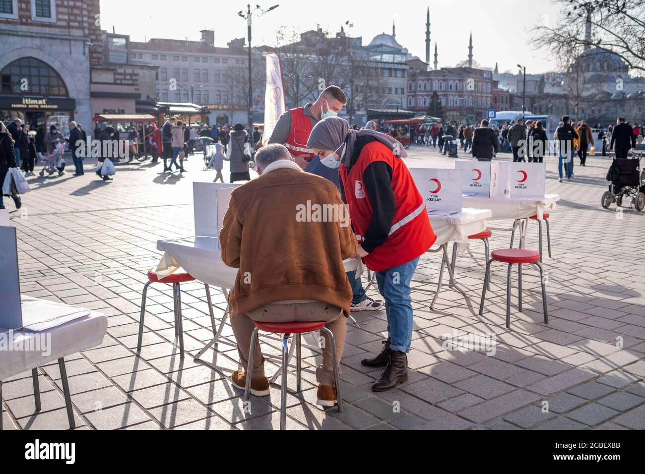 Eminonu, Istanbul, Turkey - 02.26.2021: blood donation volunteers signs checklist and Turkish Red Crescent (Turk Kizilay) employees helps them in Emin Stock Photo