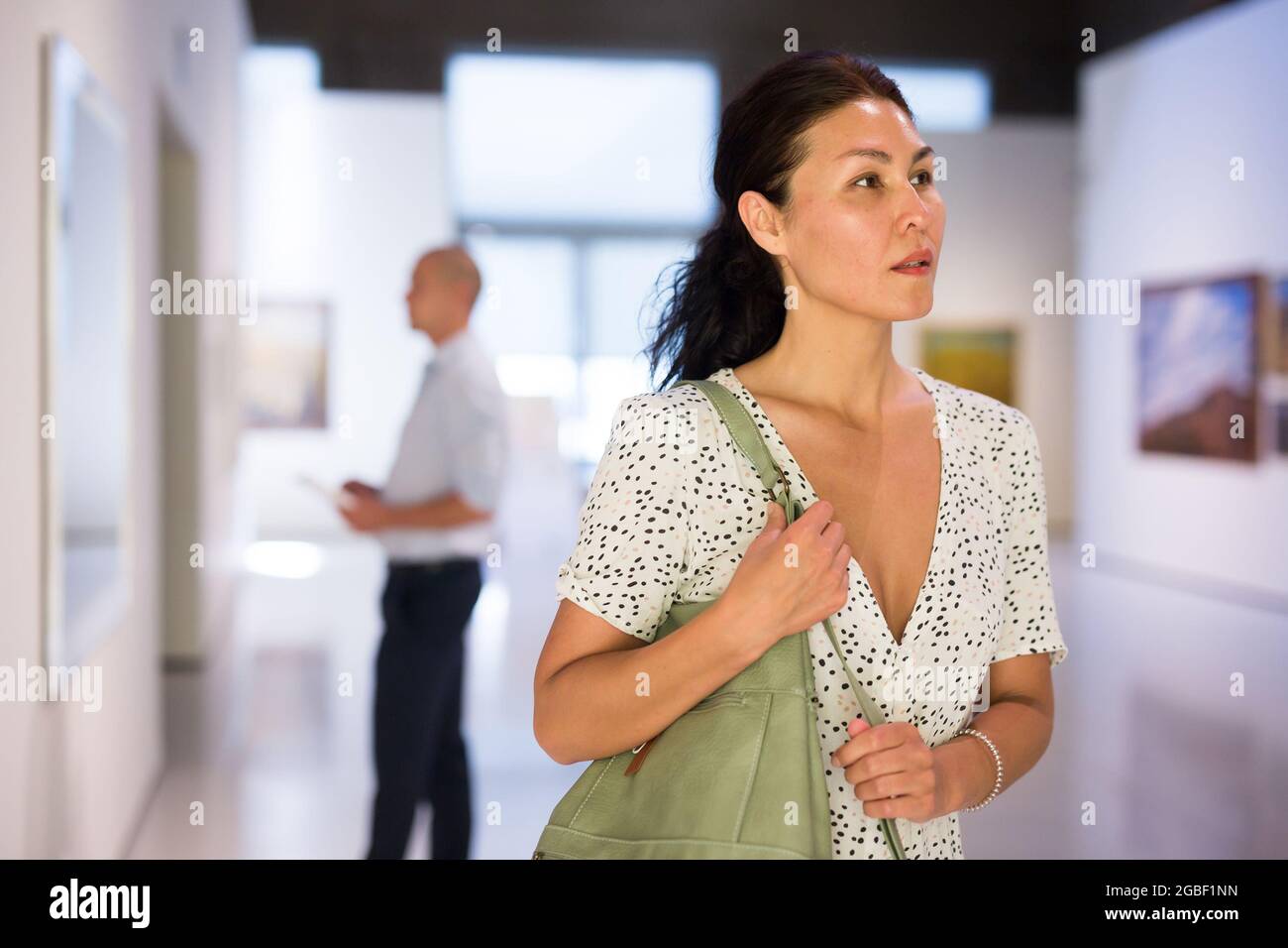 Woman standing in picture gallery Stock Photo