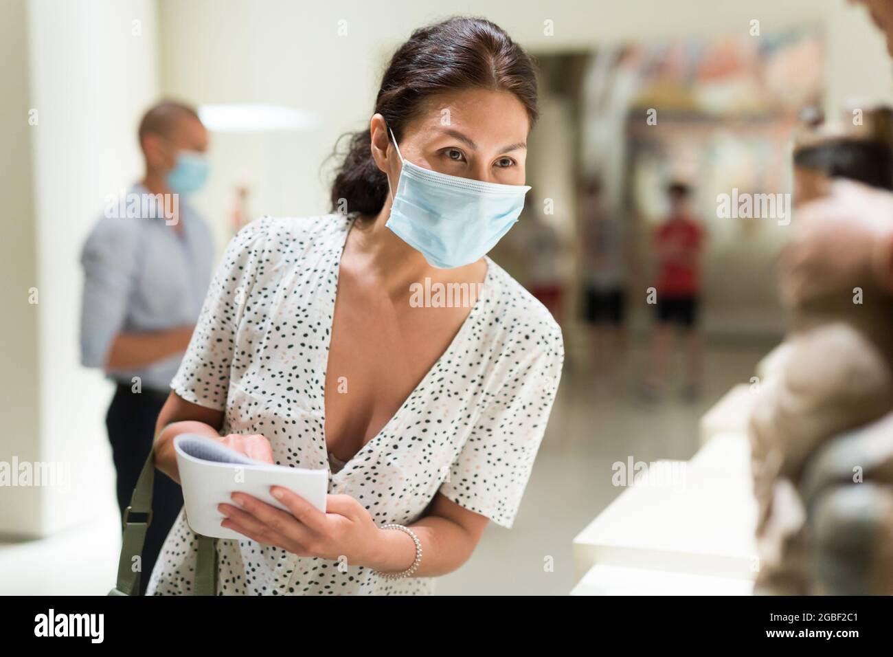 Woman standing in museum hall Stock Photo