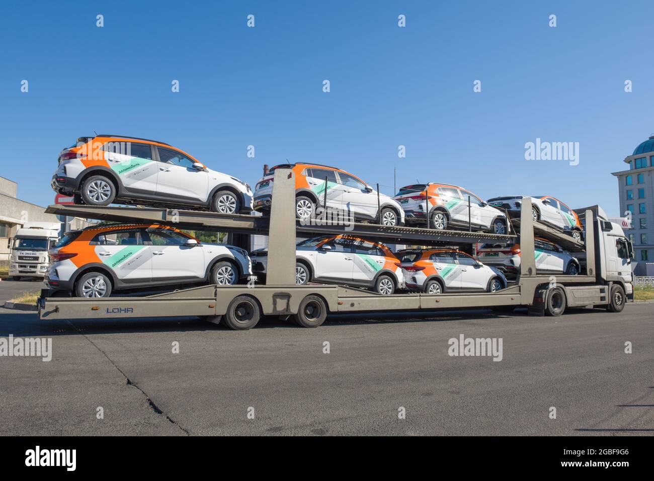 SAINT PETERSBURG, RUSSIA - JULY 17, 2021: Car carrier loaded with new cars of the Delimobil car sharing company on a sunny summer day Stock Photo