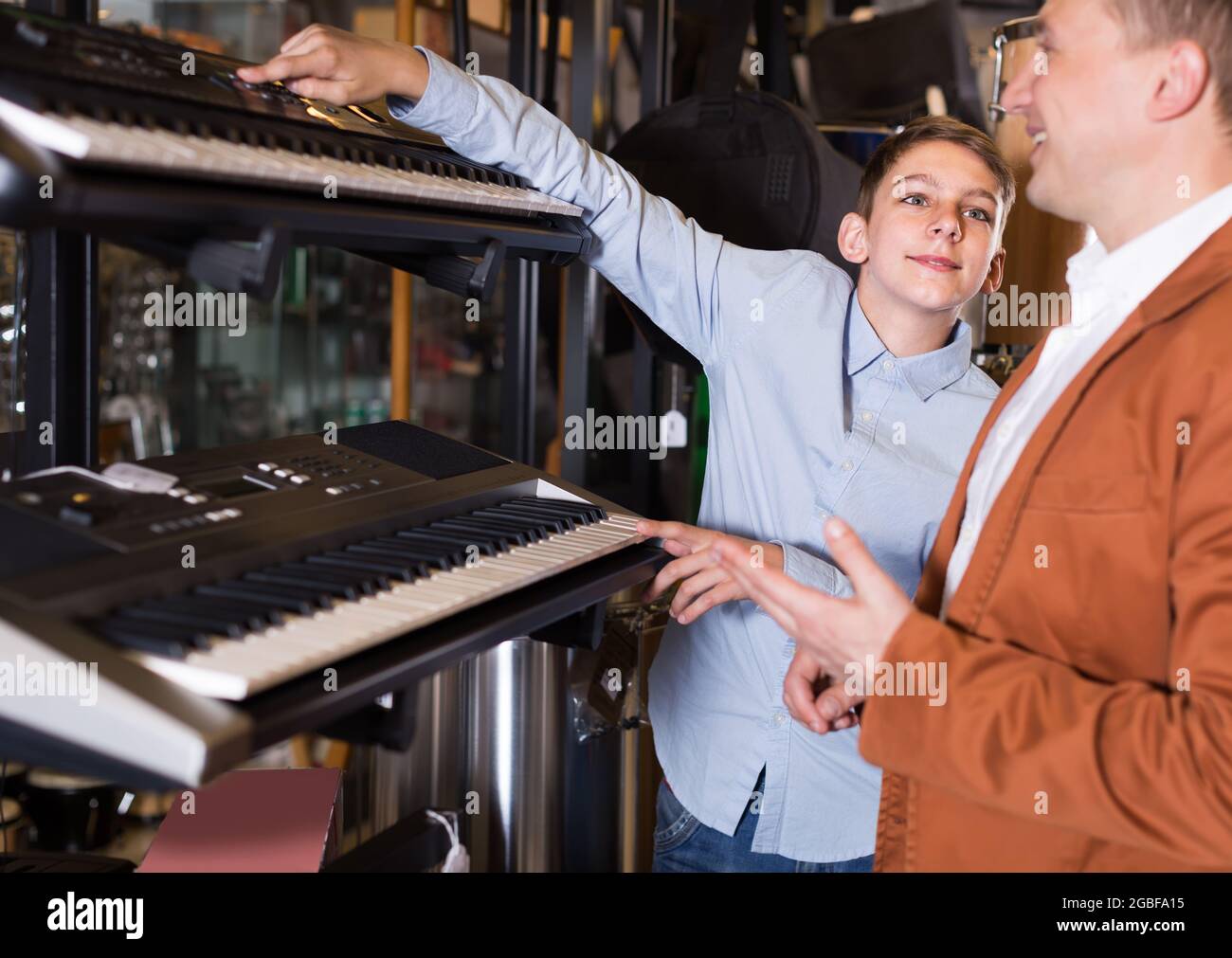 Boy with father looking at synthesizers Stock Photo