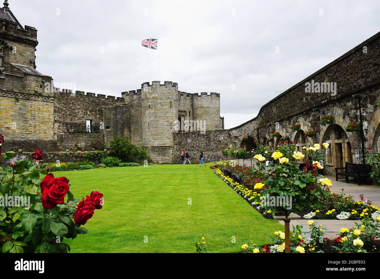 View across the formal gardens, filled with blooming roses, toward the Forework, the main entry
