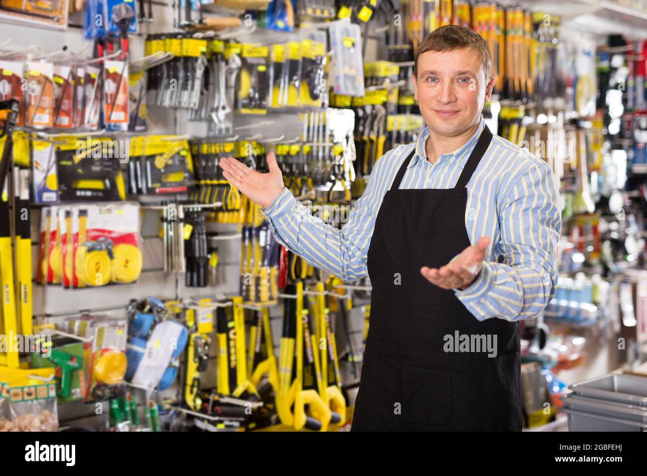 Man seller in apron having tools in hands Stock Photo