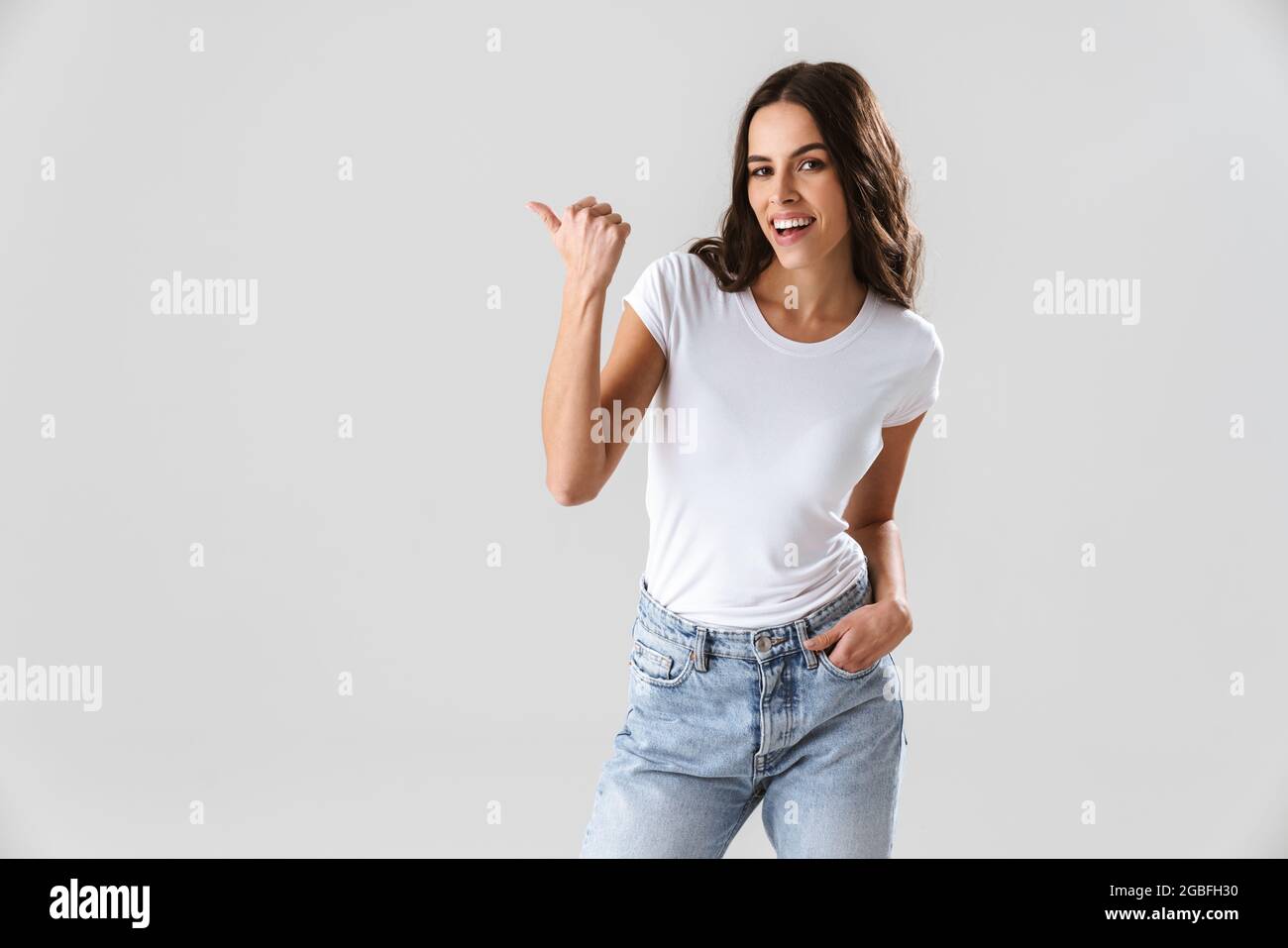Happy beautiful girl smiling and pointing finger aside isolated over ...