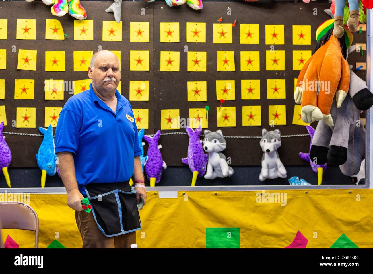 A worker mans a carnival game at the 2021 Noble County Fair in