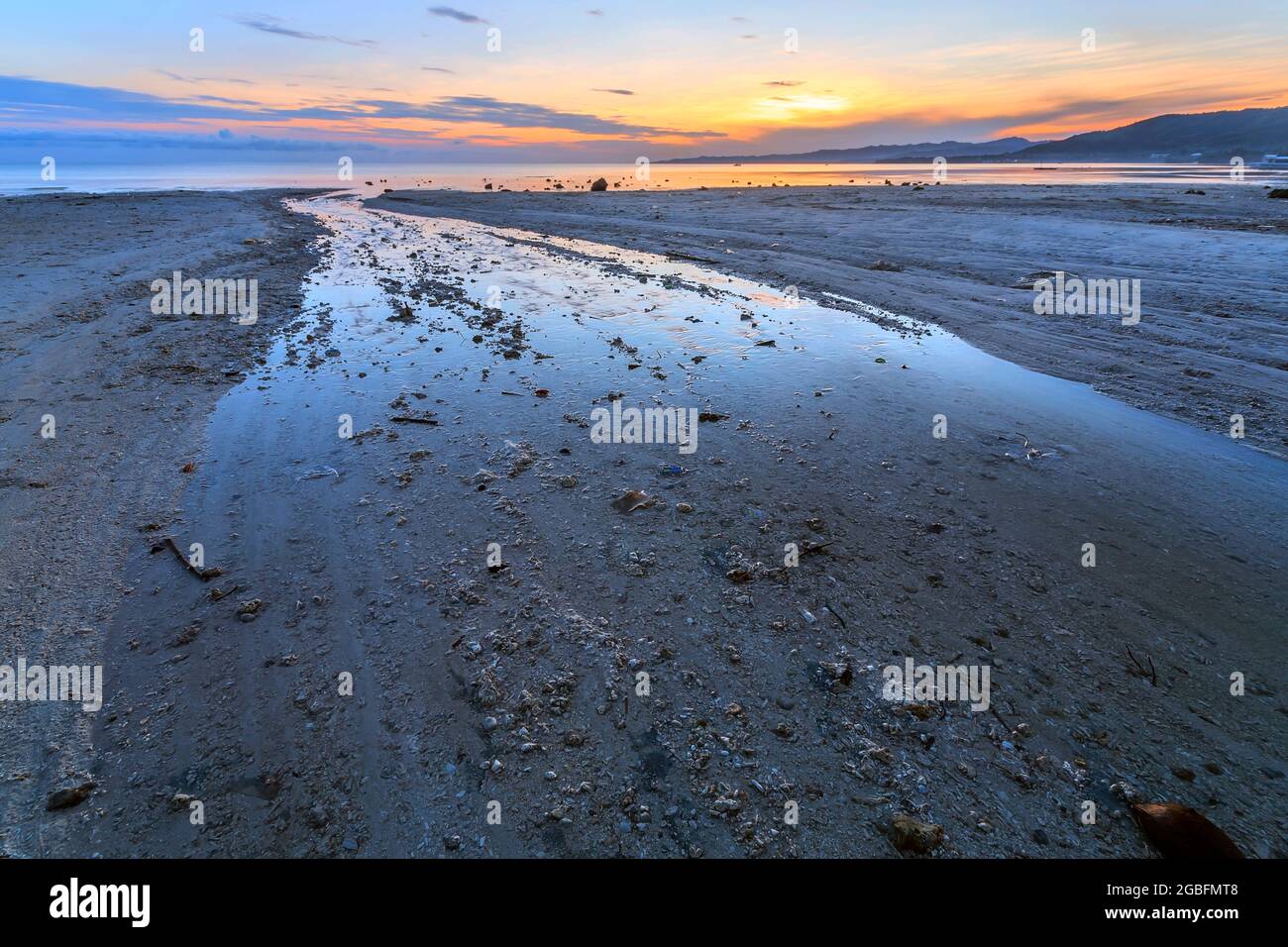 a sandy beach next to a body of water Stock Photo