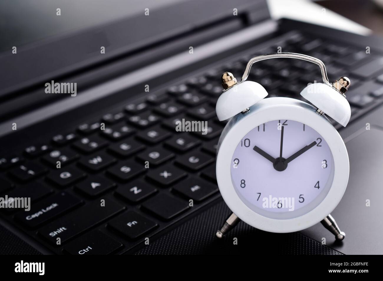 white clock on laptop computer concept for time management and