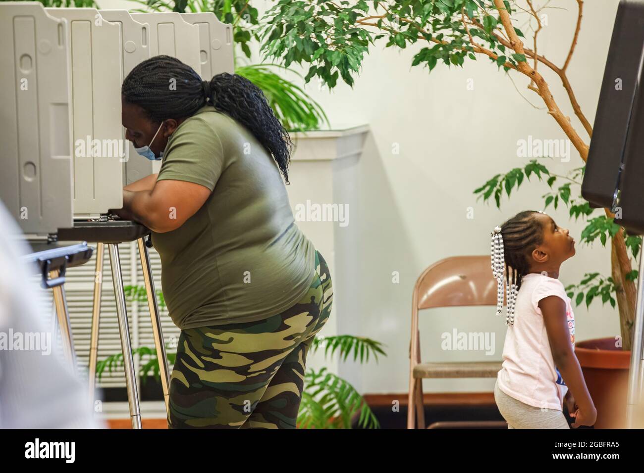 Shaker Heights, United States. 03rd Aug, 2021. Woman votes while taking