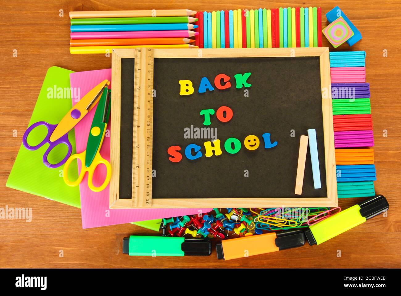 Small chalkboard with school supplies on wooden background. Back to ...