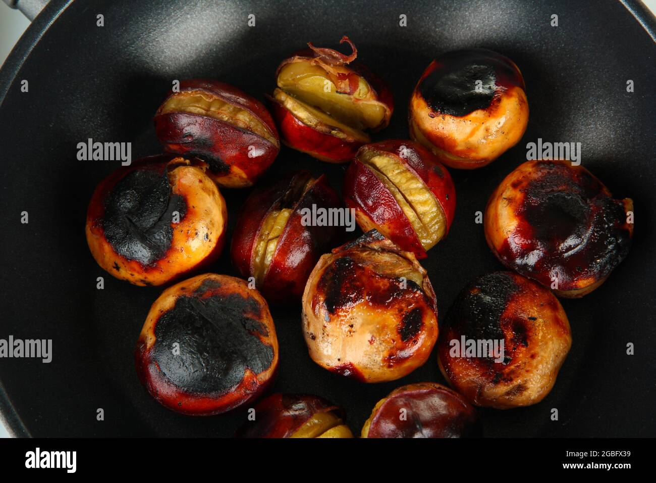 Castanas Inside roasted chestnuts in the pan close-up Stock Photo - Alamy