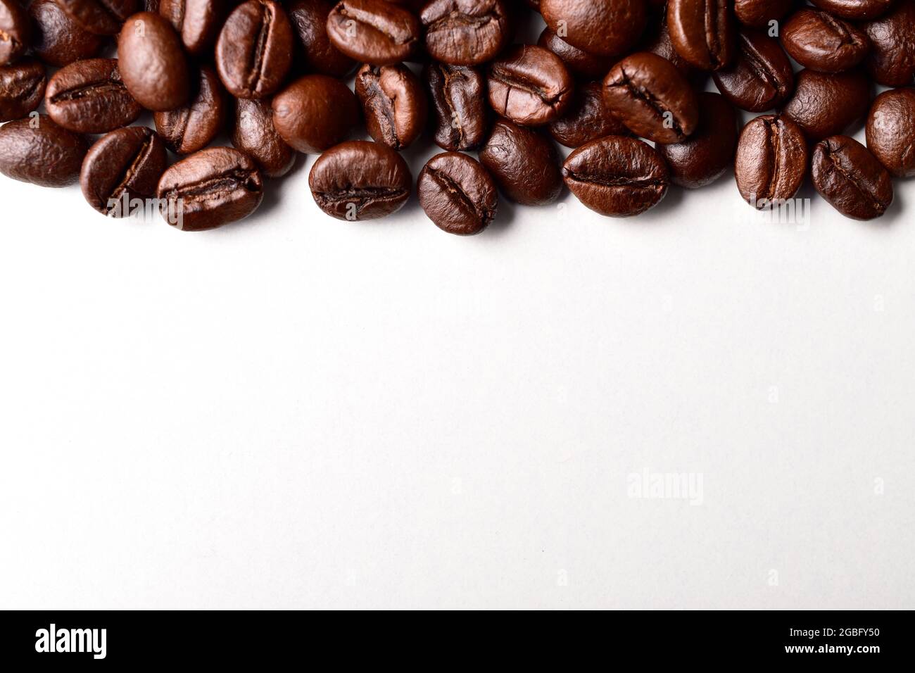 Roasted Coffee Beans On White Background With Text Space Stock Photo