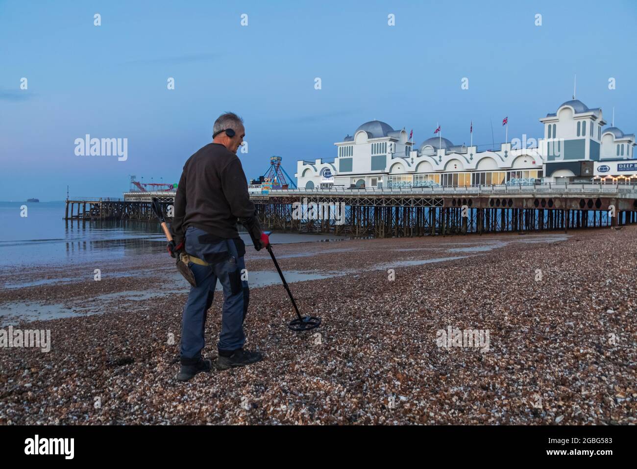 England, Hampshire, Portsmouth, Southsea, Man Metal Detecting on Beach