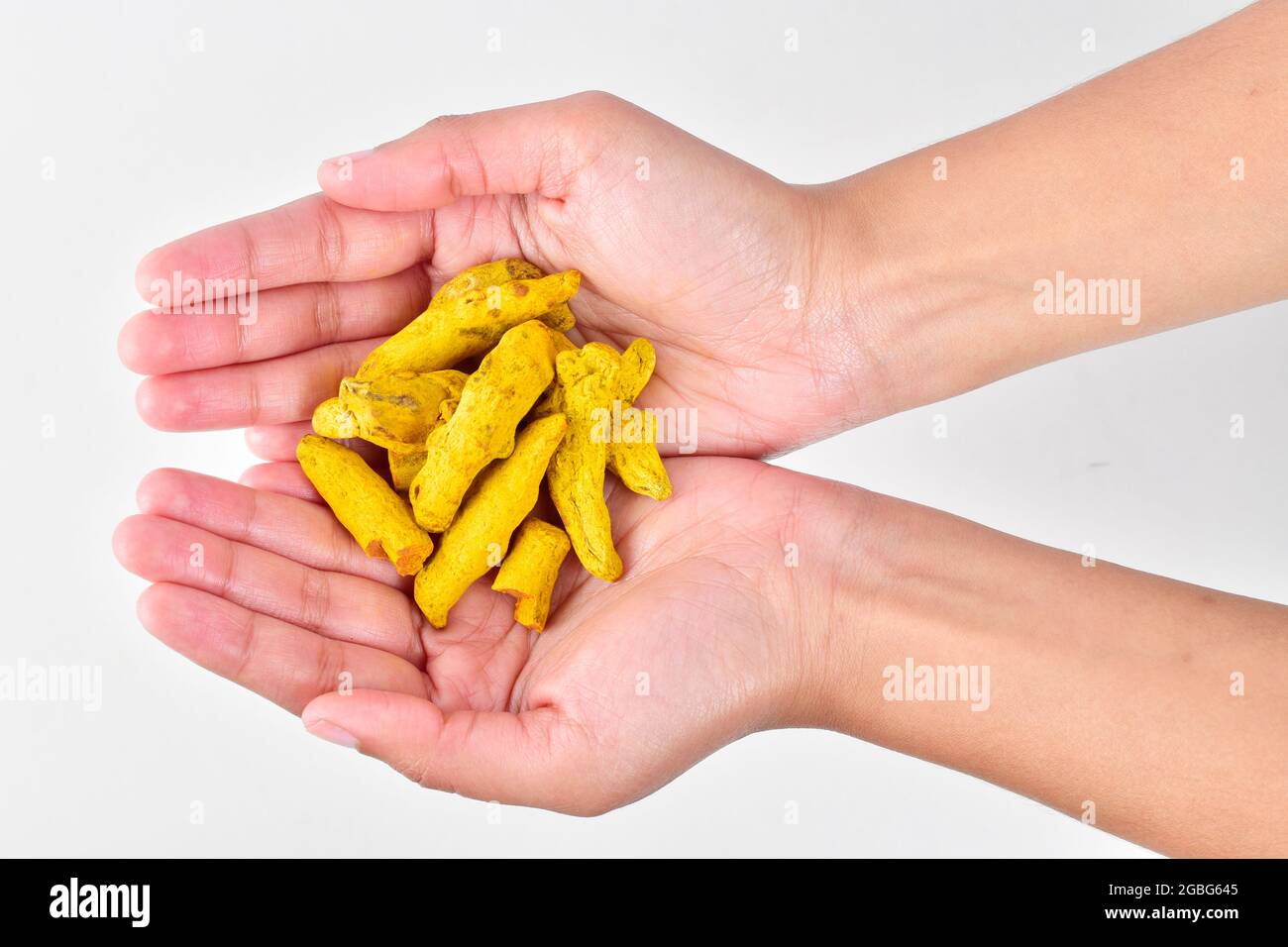 Hand holding turmeric isolated on white background with clipping path Stock Photo