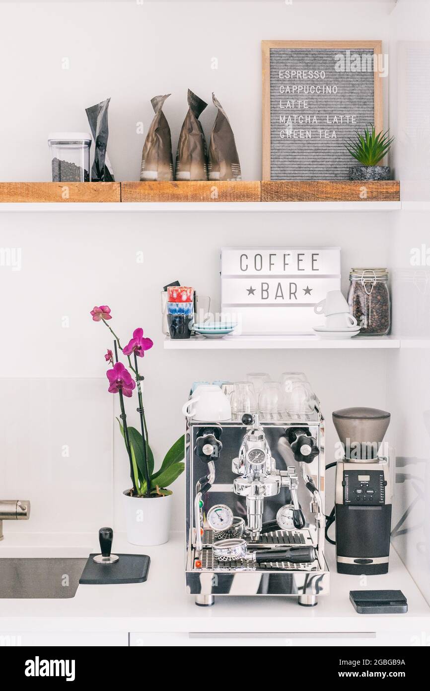 Kitchen countertop front flat view of home espresso machine styled as cafe bar with menu for espresso, cappuccino, latte, wooden trays for beans bags Stock Photo