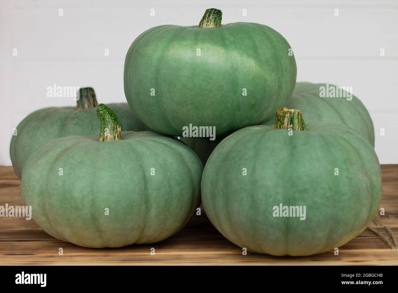Green pumpkins lying on wooden table top on a white background Stock ...