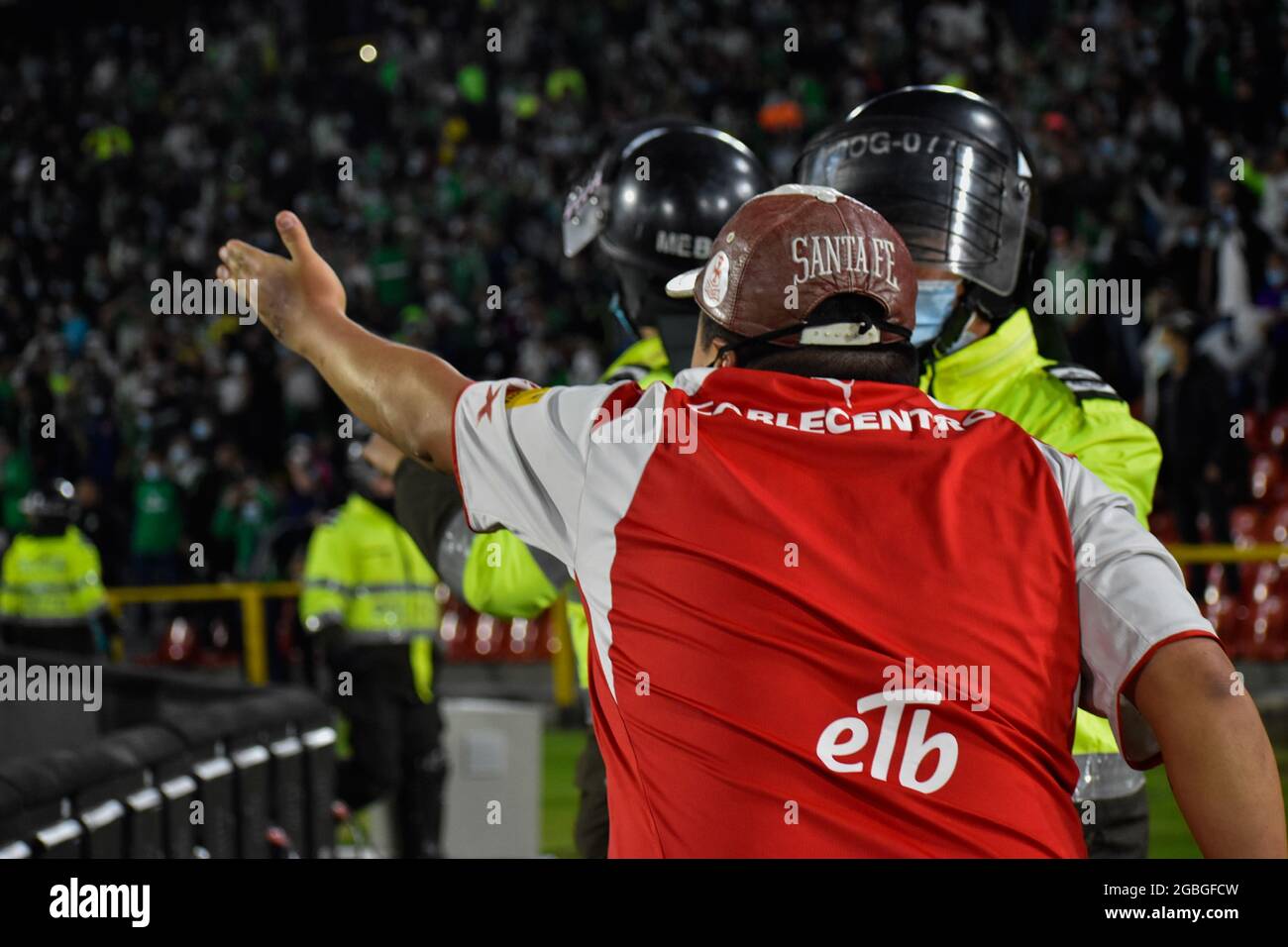 A Supporter Of Independiente Santa Fe With A Cap With The Name Team Shouts To A Police Officer As Supporters Of Independiente Santa Fe Flood The Field Of The Stadium Nemesio Camacho