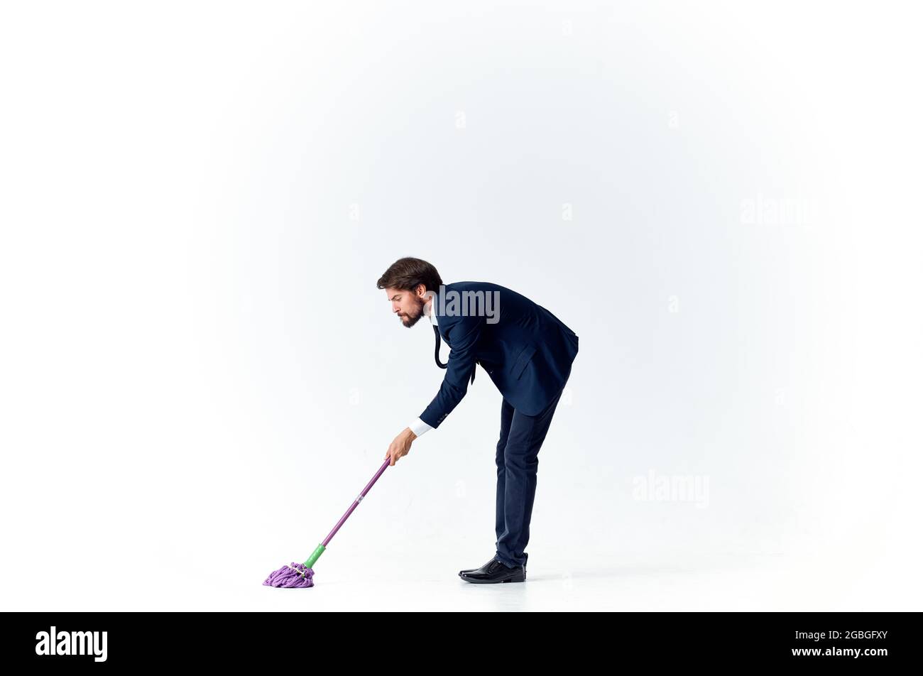 business man in a suit manager work cleaning with a mop Stock Photo