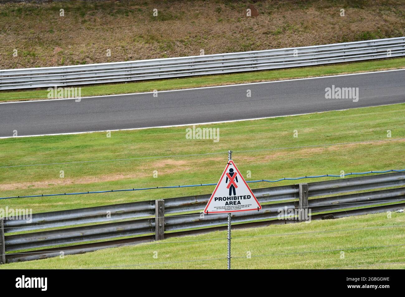 Prohibited area warning sign on a security fence over a racing circuit Stock Photo