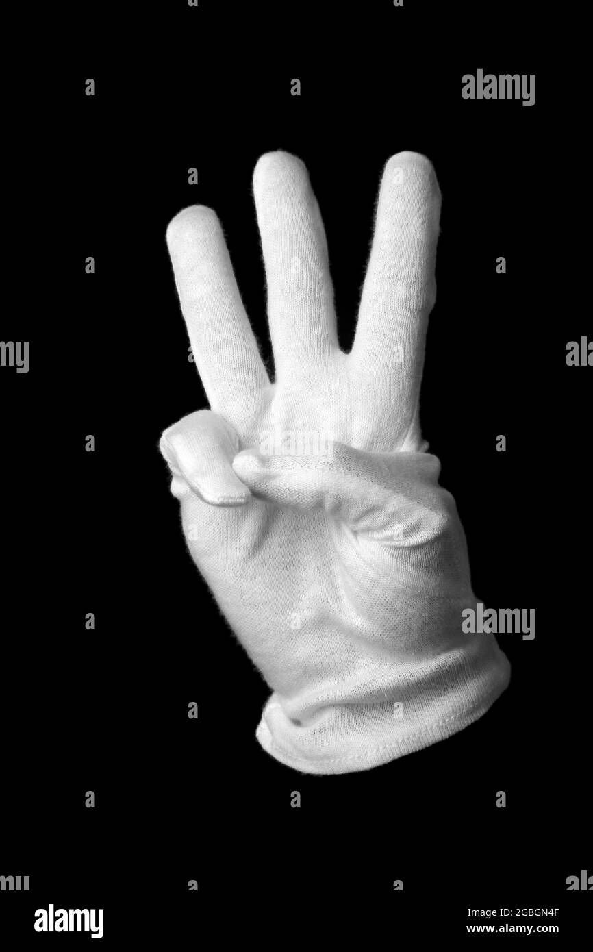 Hand in white glove making sign isolated on black Stock Photo Alamy