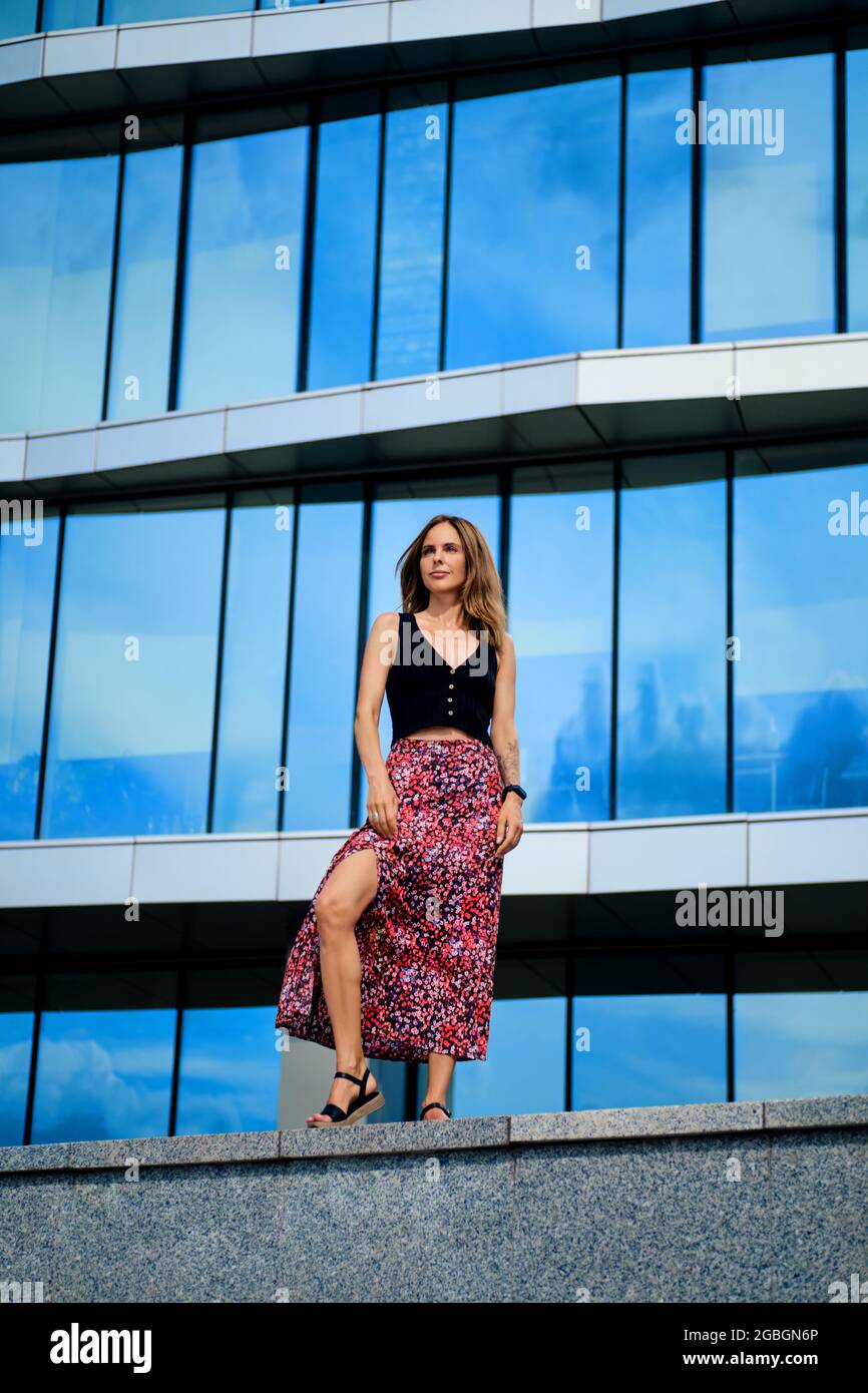 Young woman stands in front of the office building Stock Photo