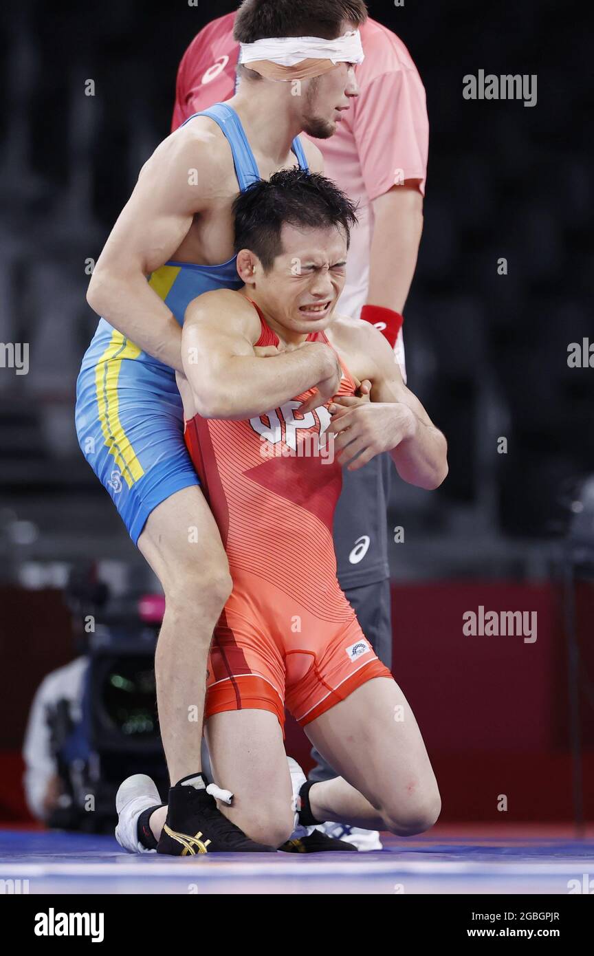 Yuki Takahashi of Japan (front) reacts after losing to Kazakhstan's