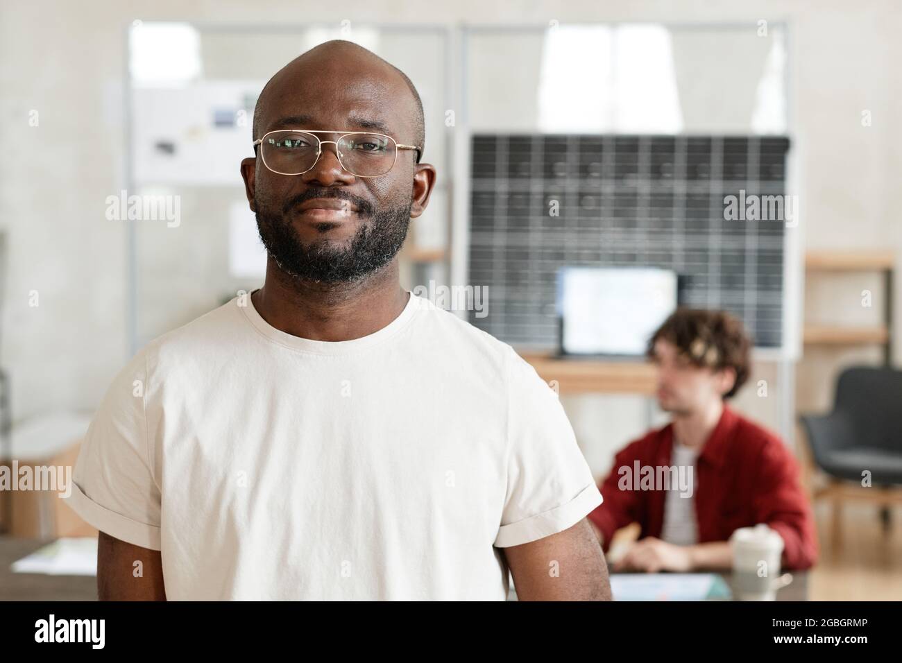 Portrait of African confident businessman in white T-shirt looking at ...