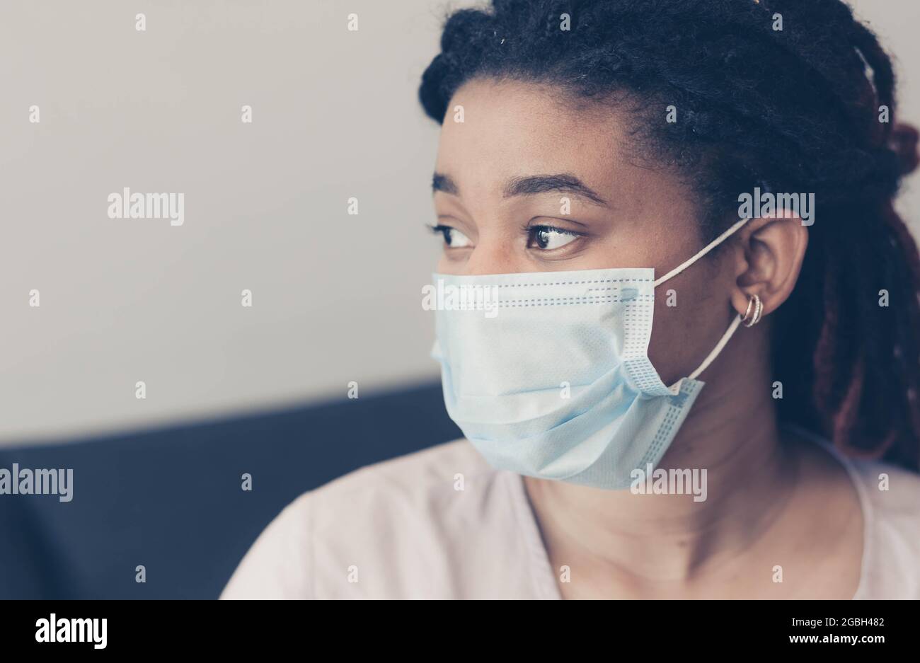 Portrait of a worried young African woman wearing a protective medical mask. color graded Stock Photo