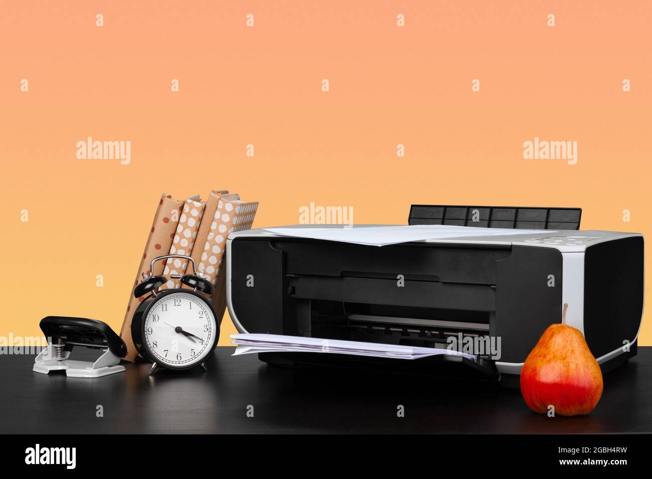 Compact home laser printer against orange background Stock Photo