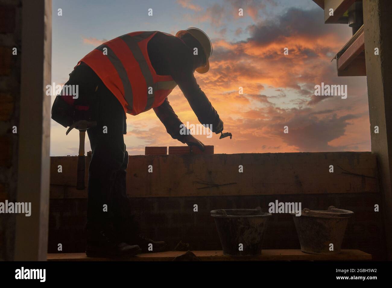 Bricklayer building a wall on a construction site, Thailand Stock Photo