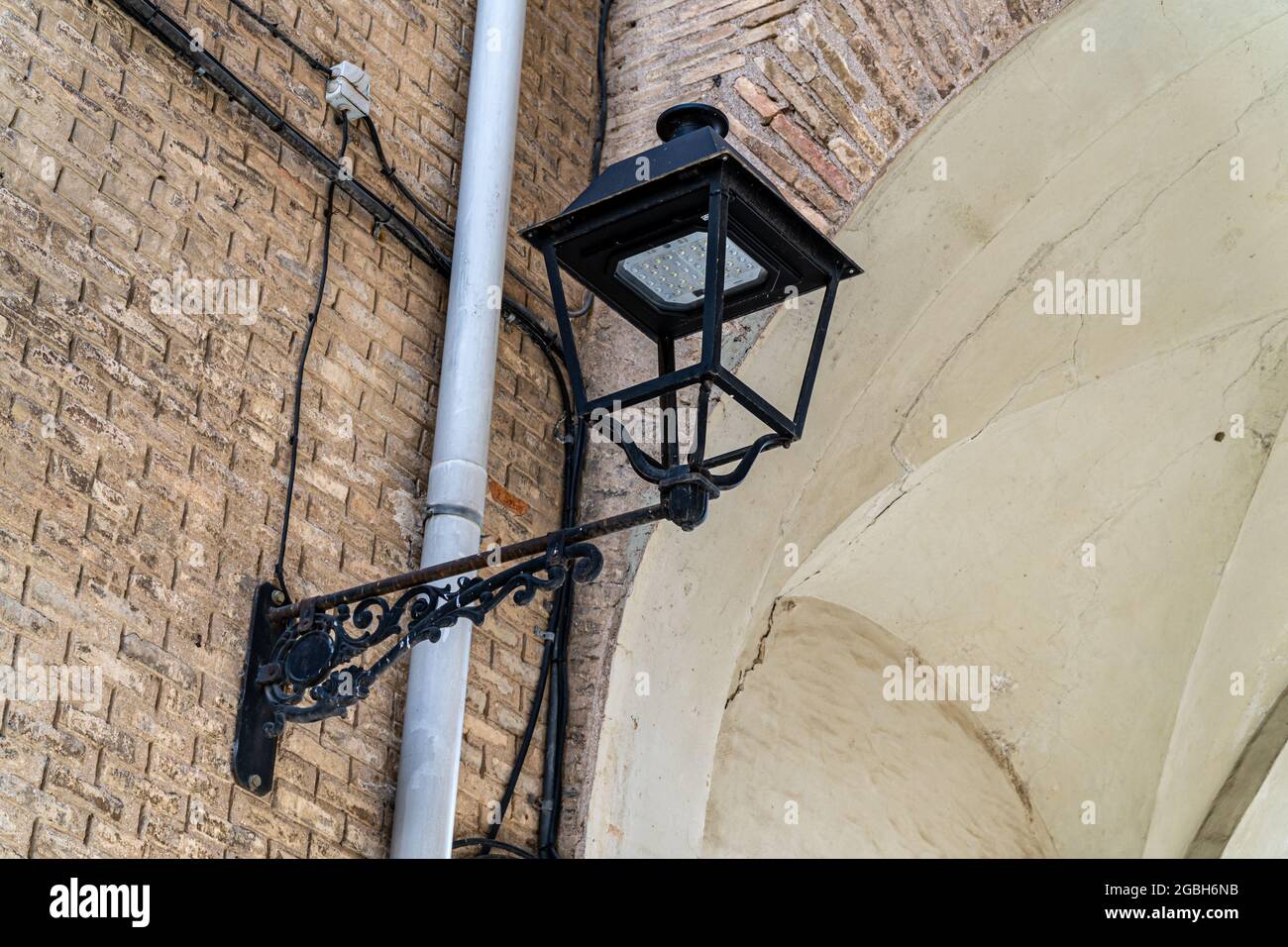 Old street lamp on a facade, modernized and remodeled with the installation of an LED Stock Photo