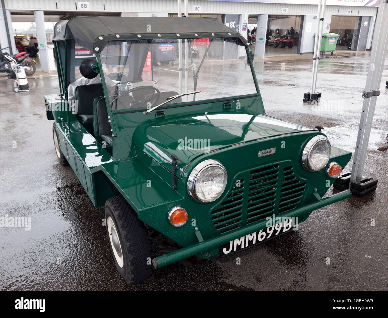 Three-Quarter Front view of a Green, 1964, Morris Mini Moke, undercover, in the National Paddock, at the 2021 Silverstone Classic Stock Photo