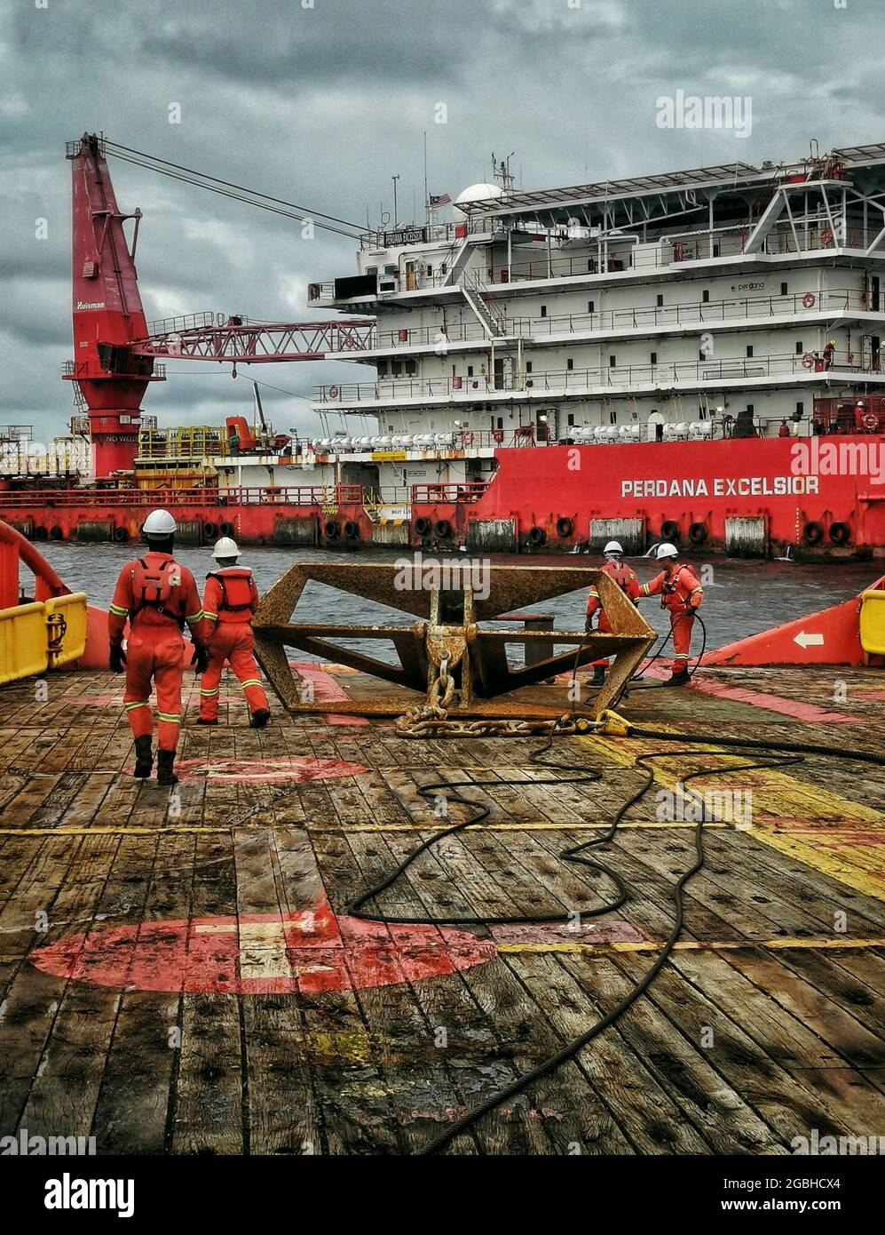 marine crew working on deck during anchor handling operation near oil platform Stock Photo