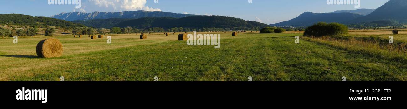 Rural fields with hay bales with mountains on the background at Rocca di Mezzo upland , Abruzzo , Italy Stock Photo