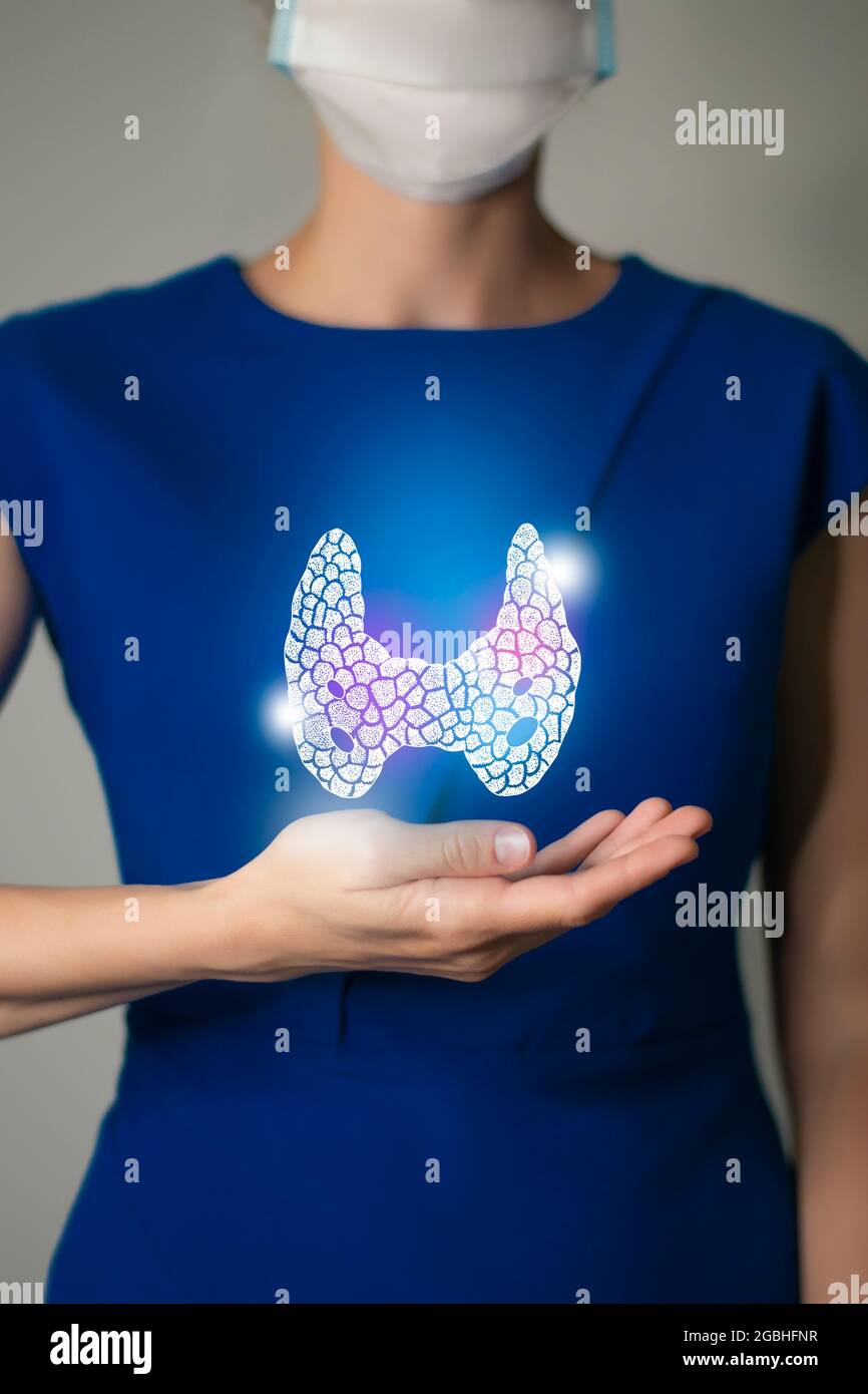 Woman in blue clothes holding virtual Thyroid Gland in hand. Handrawn human organ, detox and healthcare, healthcare hospital service concept stock pho Stock Photo