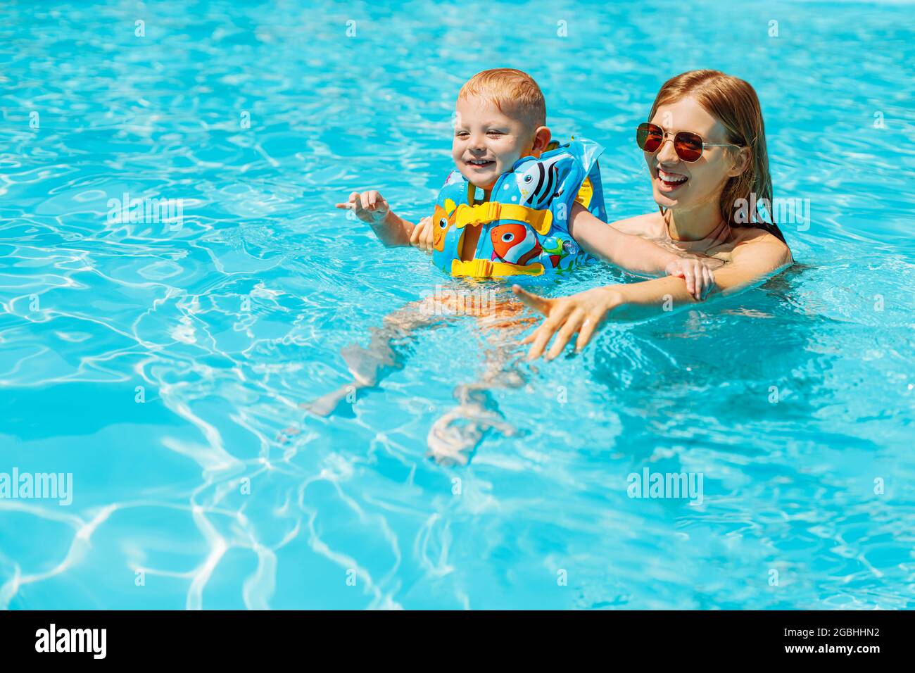 Happy family, mom and little baby swim in the pool, Happy baby learn to