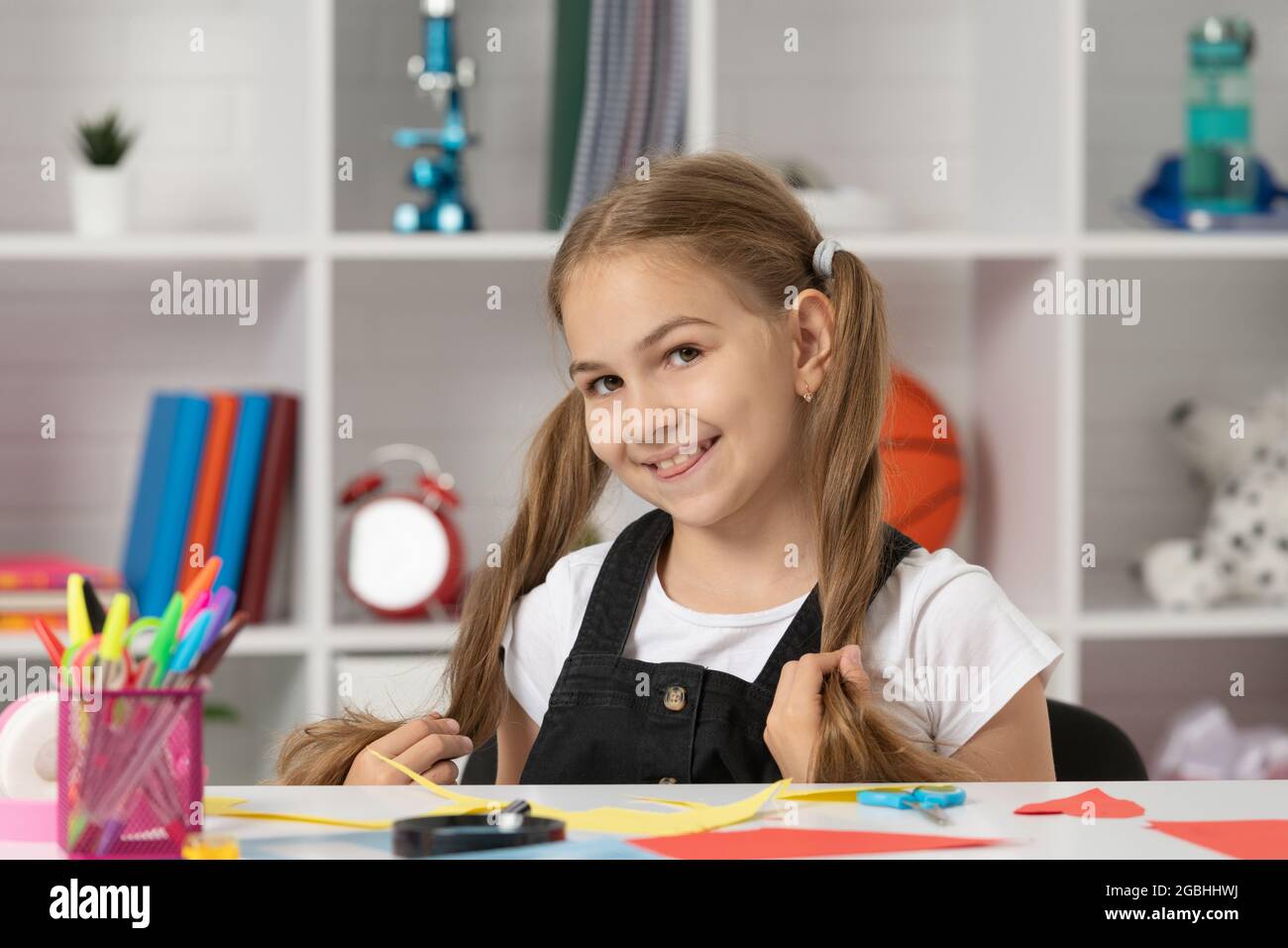 happy pretty child having fun with long hair pony tail at school lesson ...