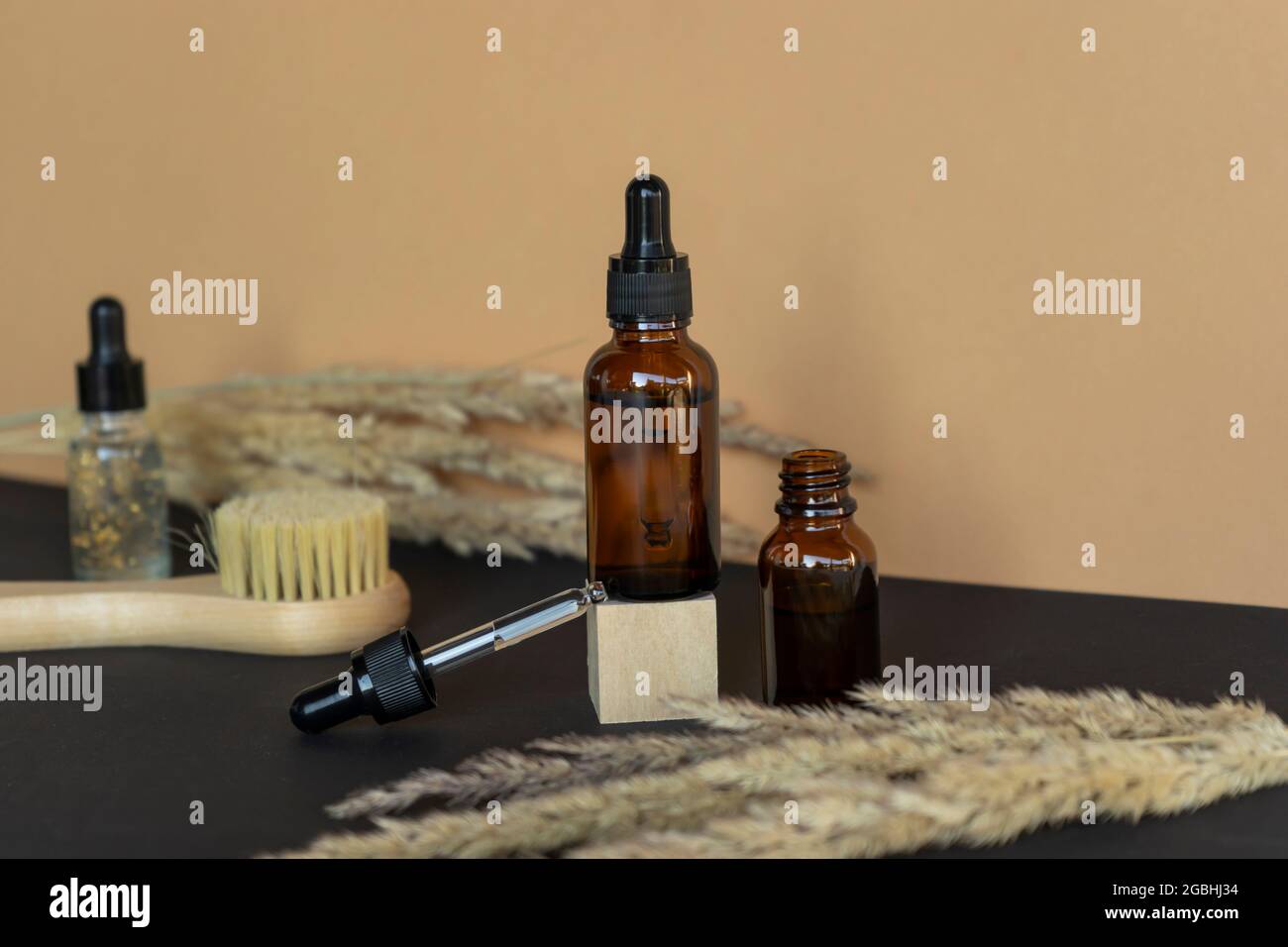 Natural essential oil or serum dropper bottles, natural facial brush lie nearby. Beauty and wellness concept. Unbranded products Stock Photo