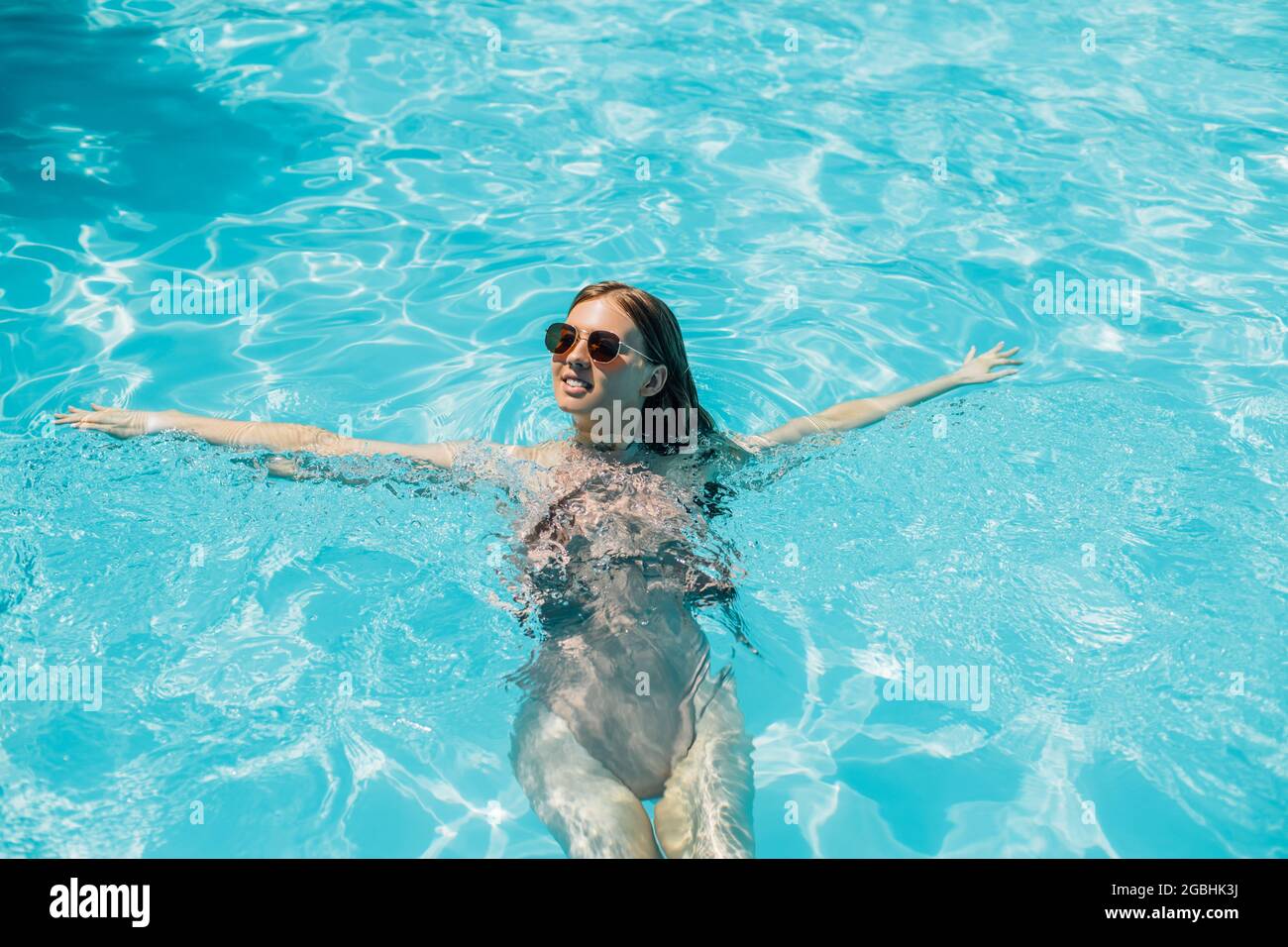 Top view, young beautiful woman in sunglasses relaxing in the water in ...