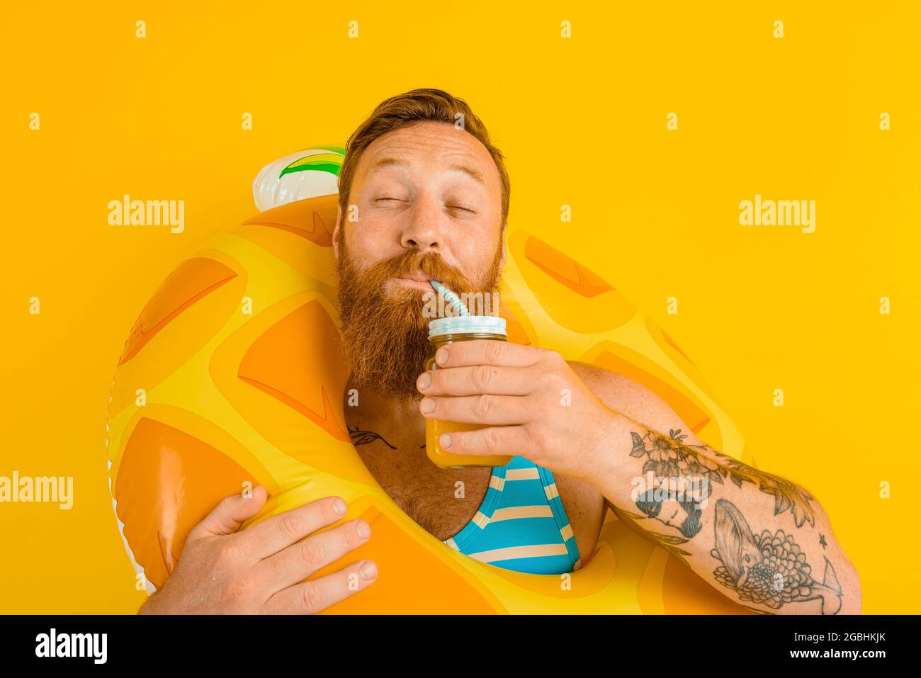 man with life buoy of child drinks a fruit juice Stock Photo