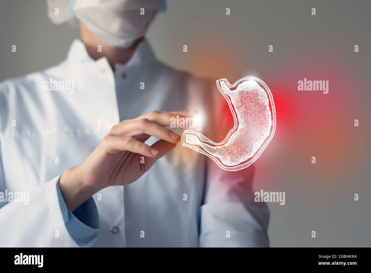 Female doctor touches virtual Stomach in hand. Blurred photo, handrawn human organ, highlighted red as symbol of disease. Healthcare hospital service Stock Photo