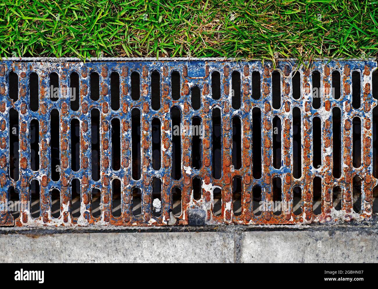 Drain water between sidewalk and garden Stock Photo