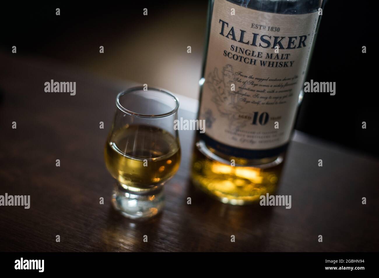 Bucharest, Romania - August 5, 2021: Illustrative editorial image of a single malt Talisker scotch whisky bottle next to a glass on counter in a pub. Stock Photo