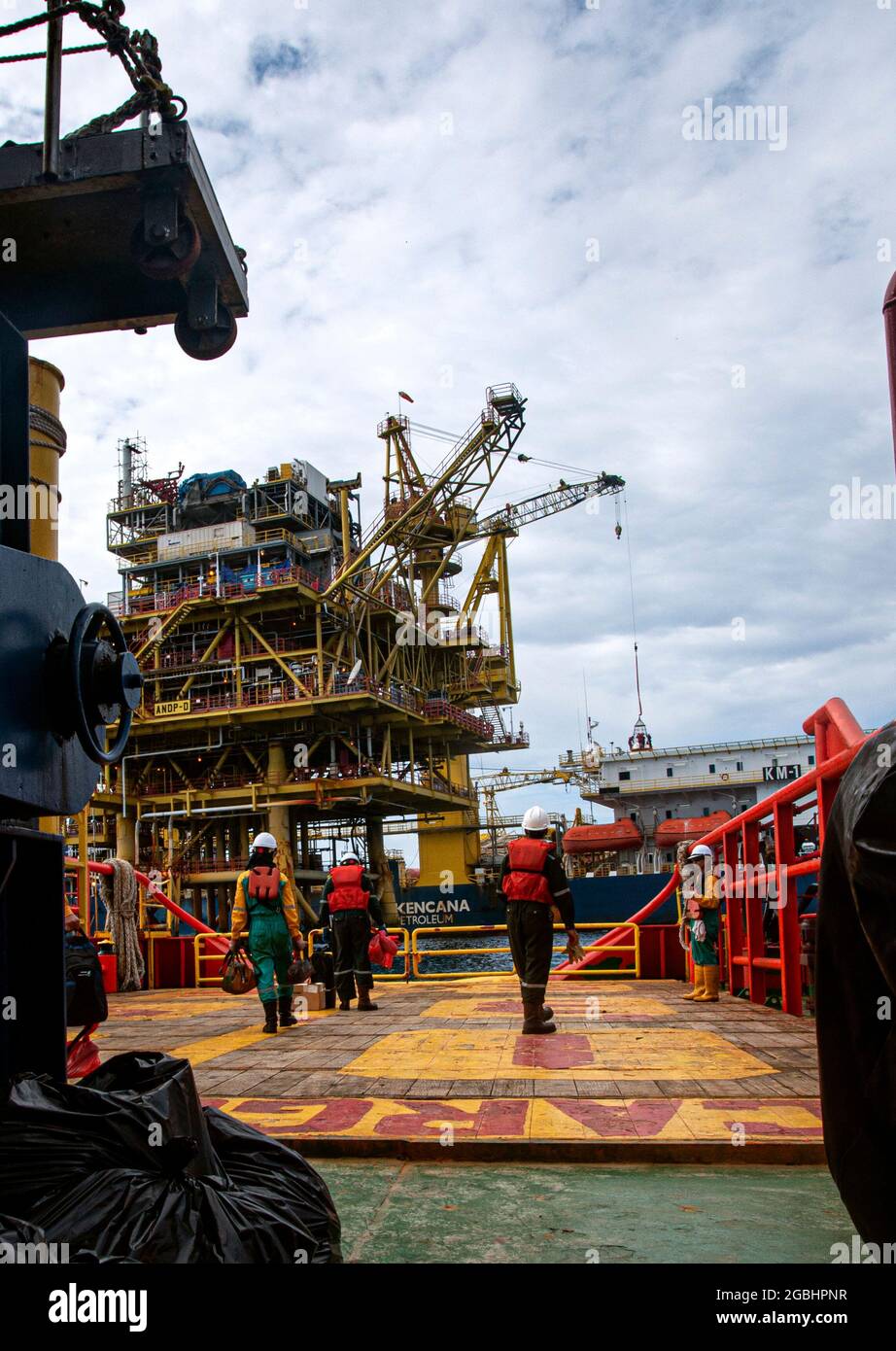 marine crew stand by on deck vessel for personal transfer from platform to vessel Stock Photo