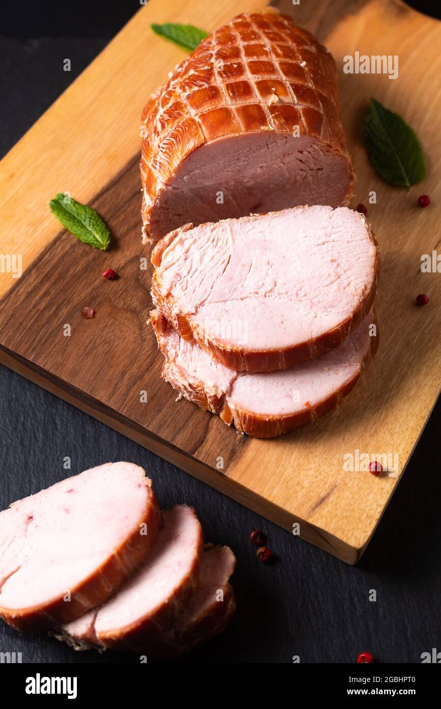 Food concept organic turkey or chicken cured ham German Kassler or Kasseler on wooden board with copy space Stock Photo