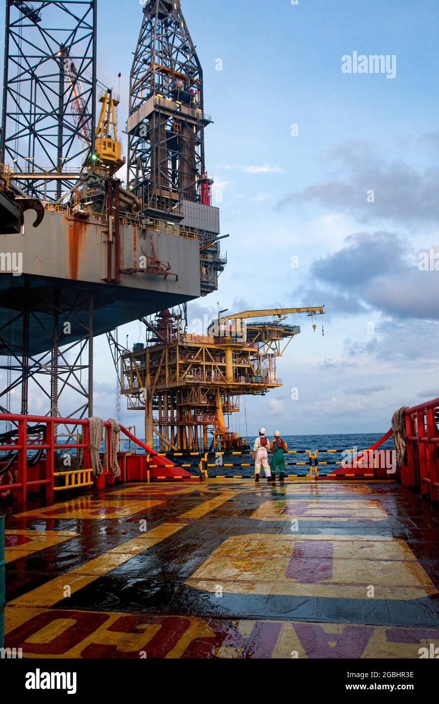 marine crew stand by on deck vessel for personal transfer from platform to vessel Stock Photo