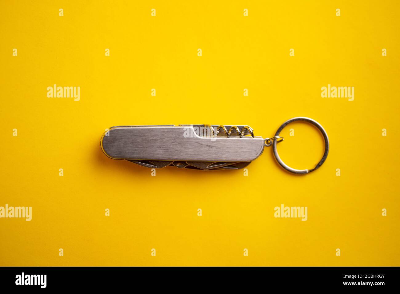 multifunctional metal knife on a yellow background. Stock Photo